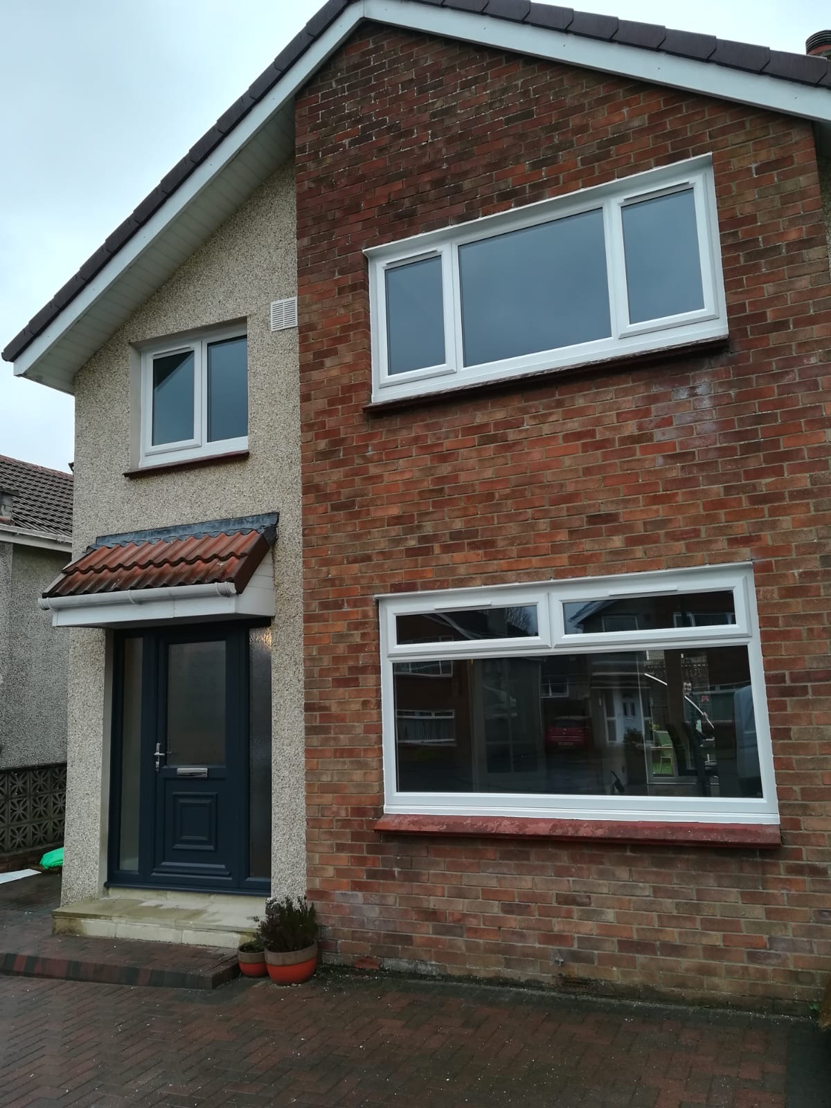 Brick detached house with navy composite door and white uPVC windows